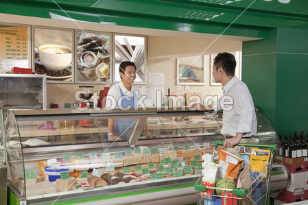 Sales Clerk assisting man at the Deli counter图