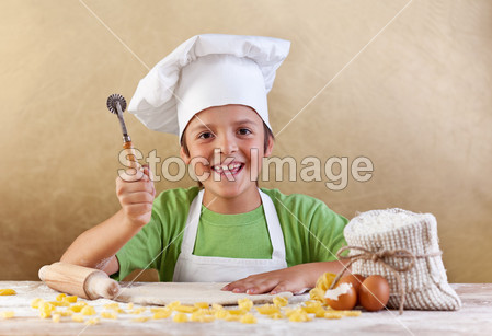 快乐的孩子与制作面食或 cookie 的厨师帽图片