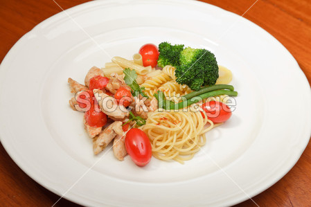 蔬菜意大利面番茄和鸡白板和木表上的晚餐图片