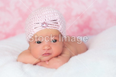 新生儿女孩穿着粉红色钩的插板风格的帽子,支