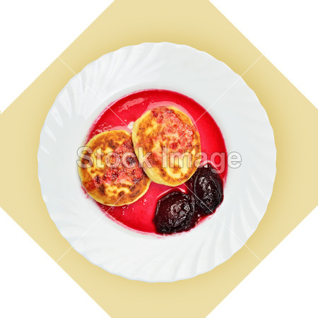 Dish of pancakes with cherry sause on white pl