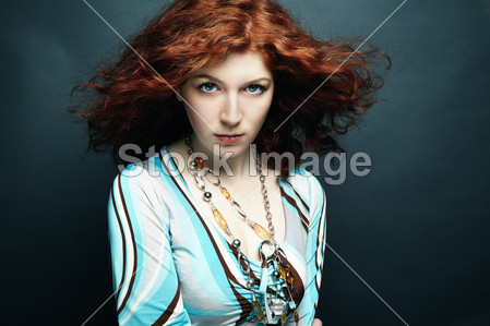 卷曲的头发的年轻美丽女子的画像图片素材(图