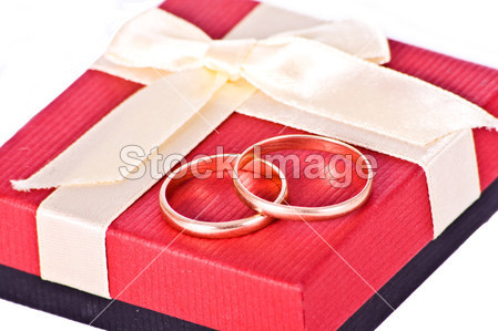 金黄婚礼圆环附近的红色礼品盒图片素材(图片