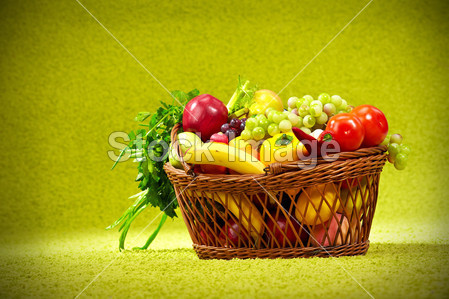 篮子里充满了新鲜的农产品。绿色背景图片素材