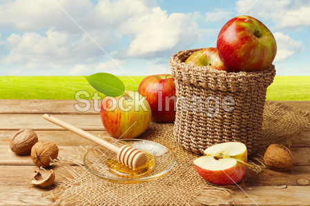 用蜂蜜在绿色草地上的木桌上的苹果图片素材(