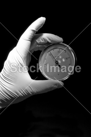 覆盖在持有圆形手表的白手套图片素材(图片编