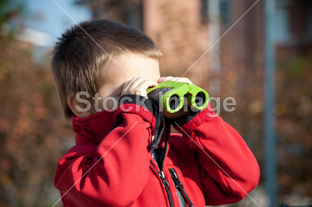 一个小男孩用双筒望远镜的画像。横向视图图片