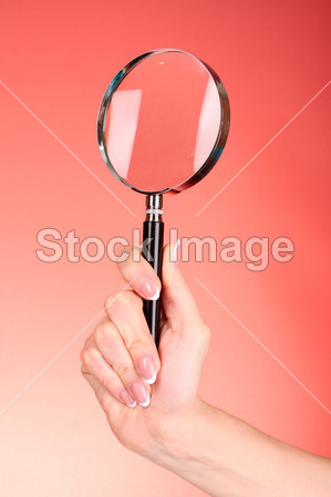 放大镜在女人手上红色背景图片素材(图片编号