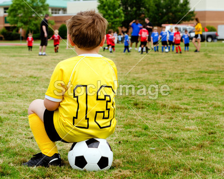 在统一看着年轻的男孩儿童举办青年足球或橄榄