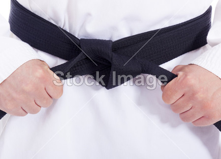 武术男子绑他的黑色皮带的特写图片素材(图片
