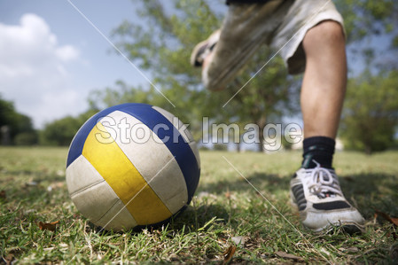 孩子们玩足球游戏,年轻男孩击中球在公园图片