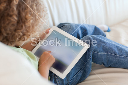背视图年轻男孩用一台平板电脑图片素材(图片