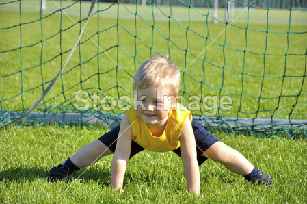 年轻的男孩或孩子扮演足球或橄榄球体育锻炼图
