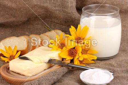 黄油面包和牛奶上解雇背景包围的木制持有图片