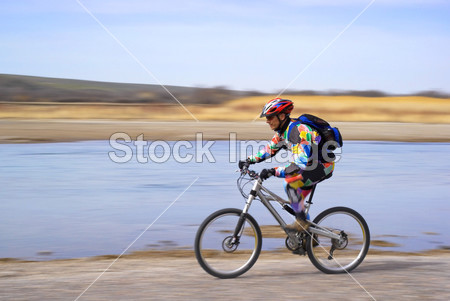 在河旁边的议案山骑自行车的速度图片素材(图