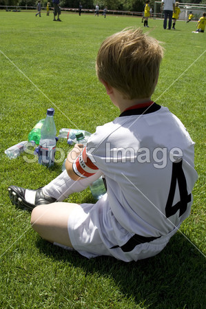 Exausted 男孩中的一场足球比赛中场休息时休