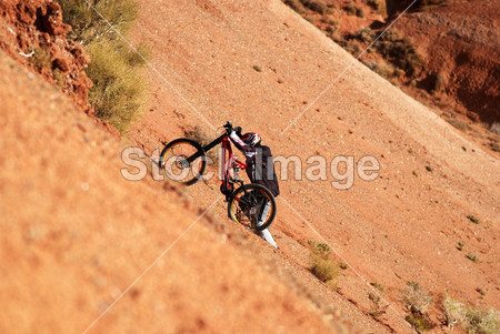 极端骑自行车上坡在红色峡谷图片素材(图片编