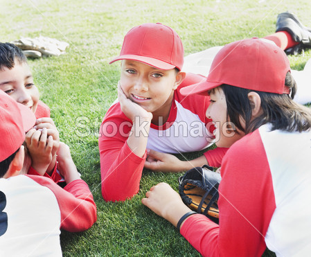 多族裔男孩在草地上铺设的棒球制服图片素材(