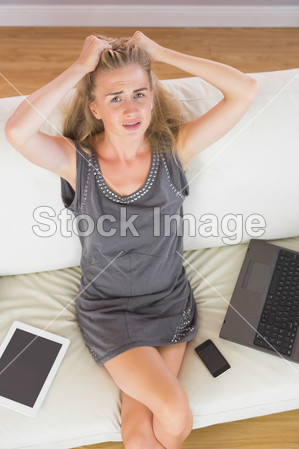 Casual upset blonde relaxing on couch next to s