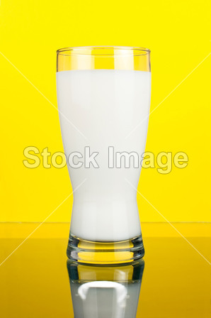 一杯新鲜的牛奶暗黄色背景上图片素材(图片编