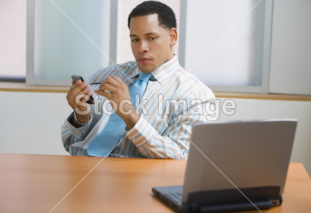 非洲裔美国商人在与掌上电脑和笔记本电脑桌图