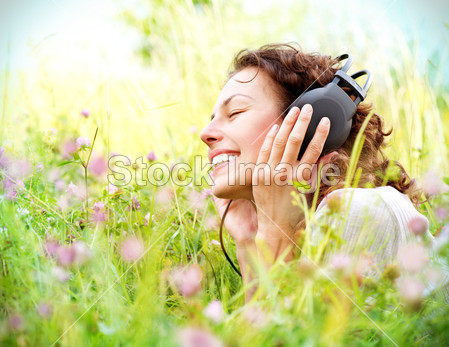 美丽的年轻女子带耳机户外活动。享受音乐图片