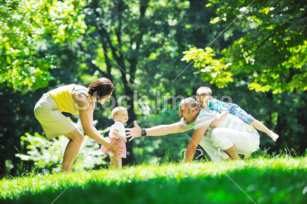 快乐年轻夫妇和他们的孩子在公园玩得开心(图