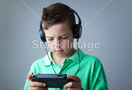 男孩玩游戏控制台灰色背景图片素材(图片编号