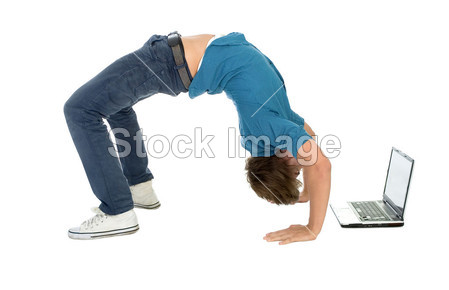年轻男子向后弯腰时使用的便携式计算机图片素