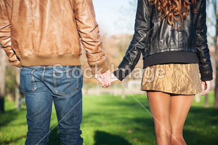 手牵手浪漫的年轻夫妇在秋天公园户外散步图片
