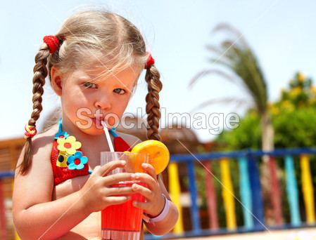 儿童女孩在眼镜和红色比基尼喝果汁图片素材(