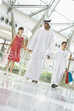与两个孩子在一家购物中心的中东男子图片素材