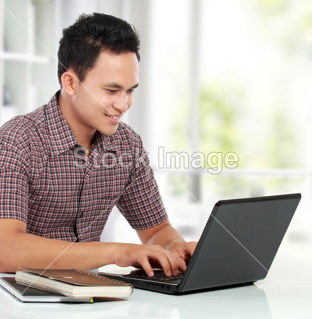 男人在他办公桌前工作用的笔记本电脑图片素材
