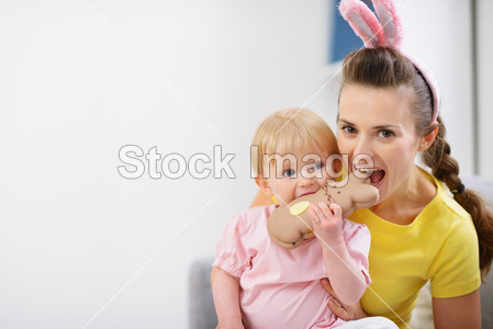 母亲和婴儿咬巧克力复活节兔子 cookie图片素