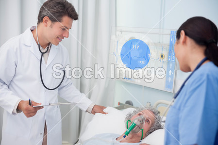 医生和护士检查病人躺在数字屏幕显示心电数据