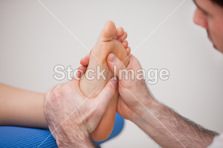 足科医师练习对女人的脚脚底按摩图片素材(图