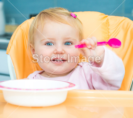 One year old girl in a highchair for feeding图片素