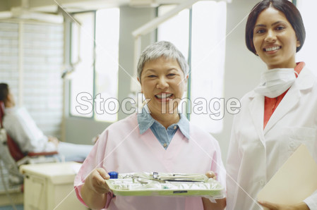 印度女牙医和微笑的高级亚洲女性牙科助理图片