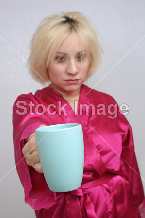 脾气暴躁的金发女郎伸出她的咖啡杯图片素材(