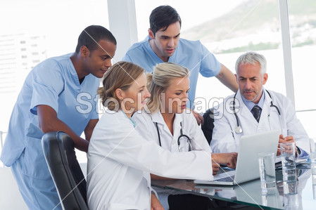 使用一台笔记本电脑的严重医疗团队图片素材(